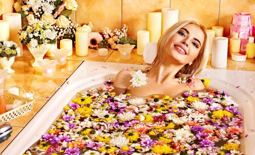 La fille prend une salle de bain avec des pétales